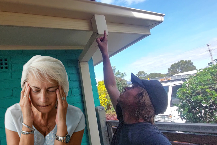 a merimbula downpipe cleaner is pointing towards a blocked downpipe after gutter rinsing service